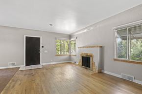 Denver apartment for rent - an empty living room with a fireplace and wooden floors